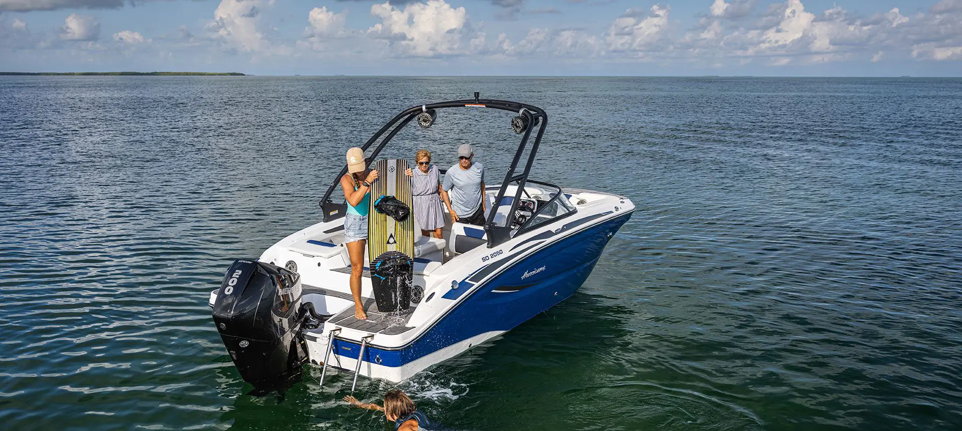 person preparing to wakeboard behind a hurricane deck boat on the ocean