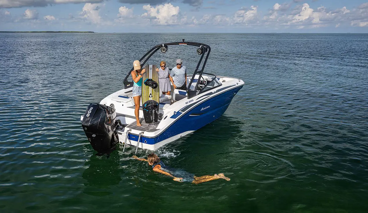 person preparing to wakeboard behind a hurricane deck boat on the ocean