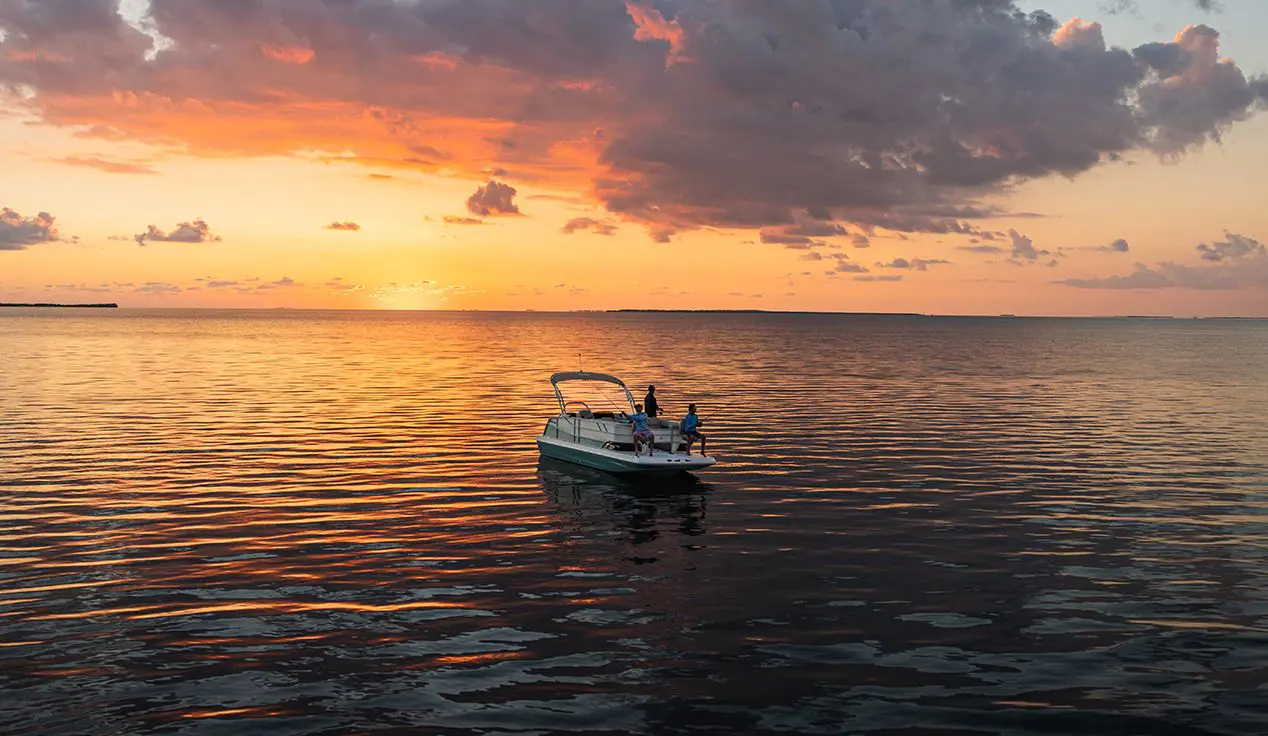 People fishing off a Hurricane deck boat on the ocean.