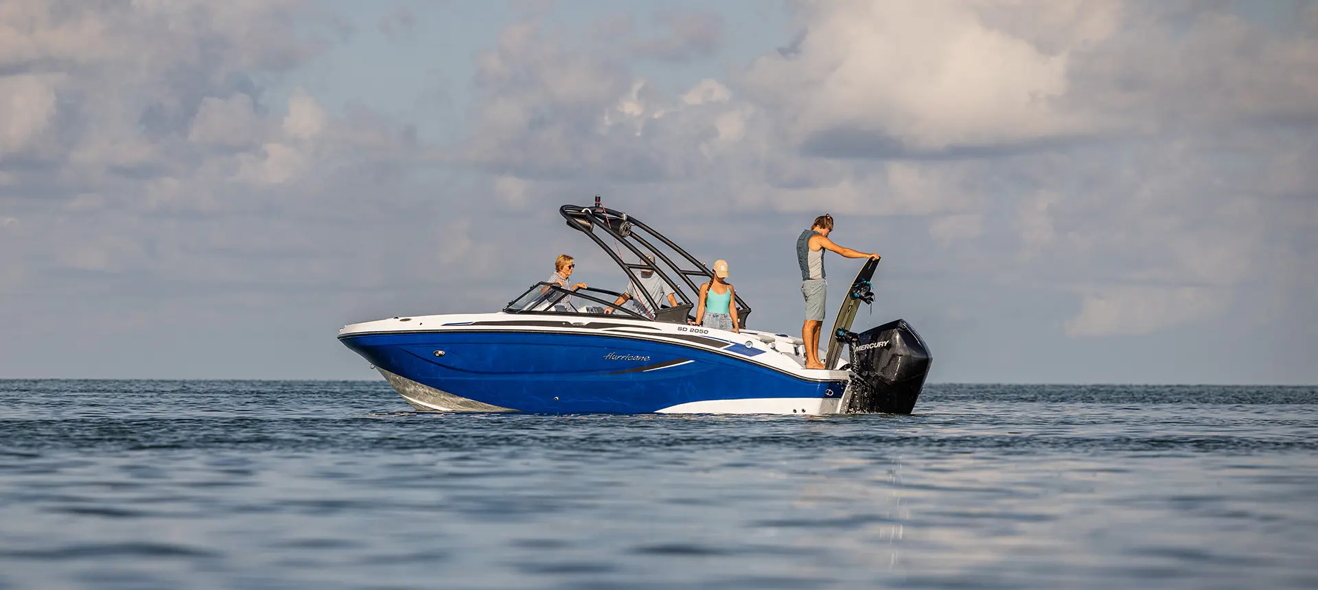 person preparing to wakeboard behidn a hurricane sport boat