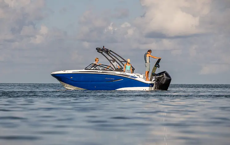 person preparing to wakeboard behidn a hurricane sport boat