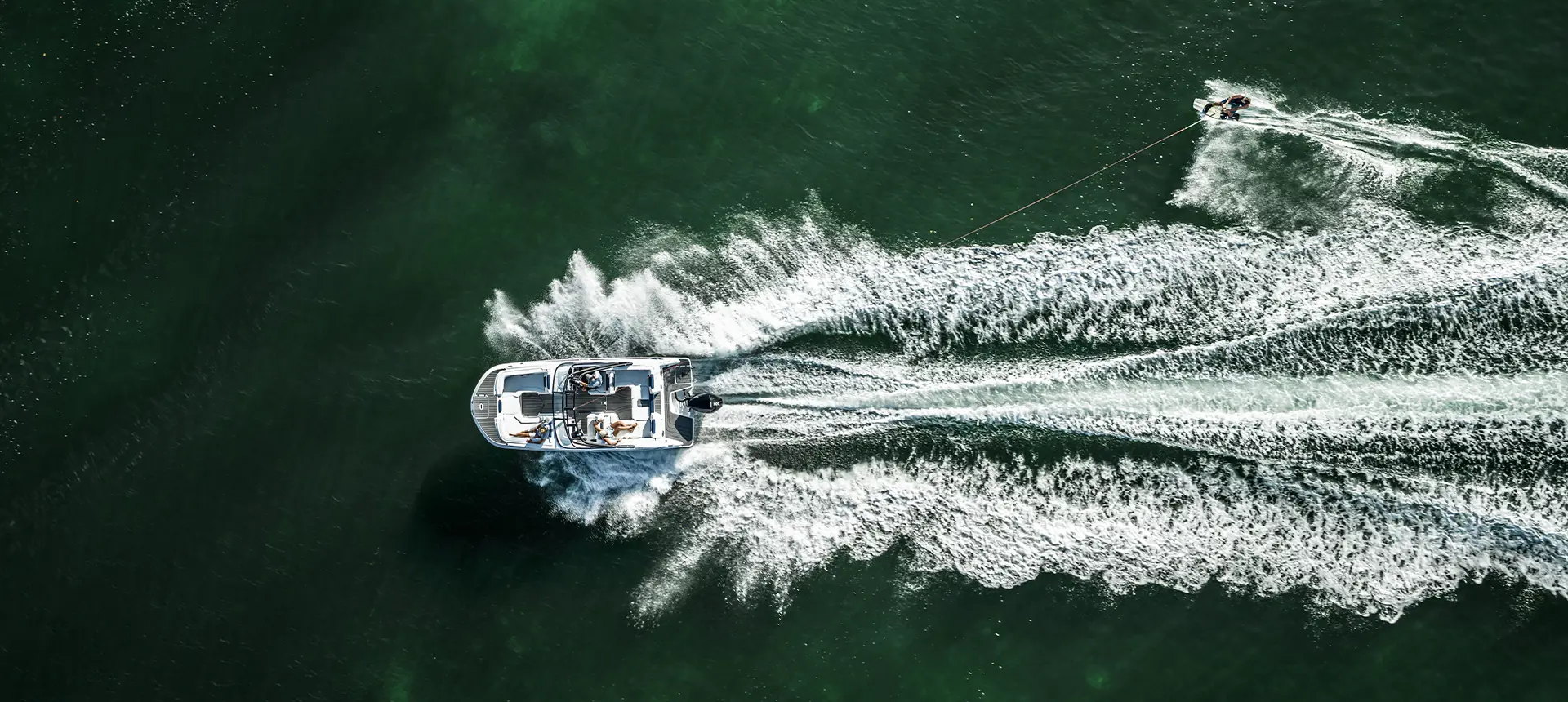 Aerial view of a person wakeboarding behind a Hurricane sport boat.