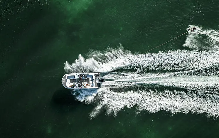 Aerial view of a person wakeboarding behind a Hurricane sport boat.