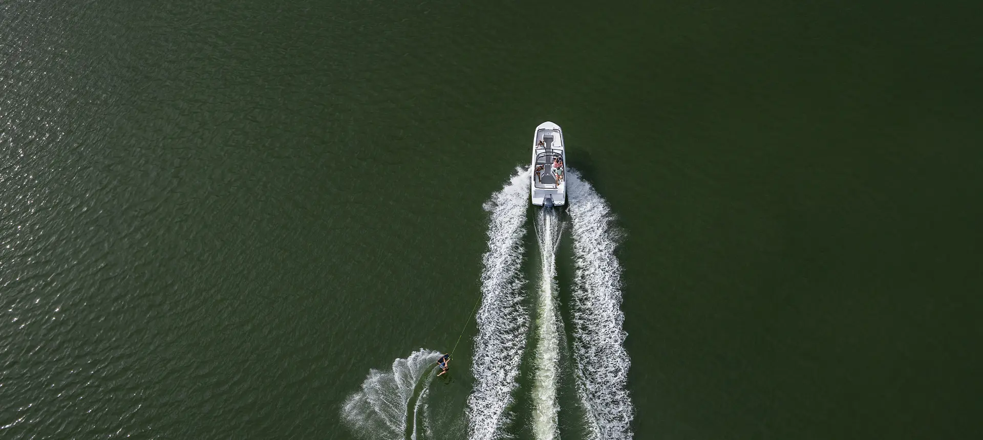 Aerial view of a Hurricane sport boat pulling a wake boarder.