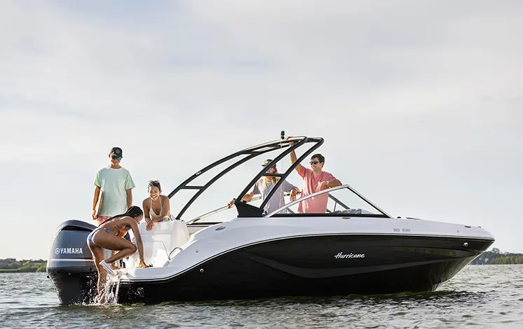 Girl climbing up ladder on a Hurricane sport boat.