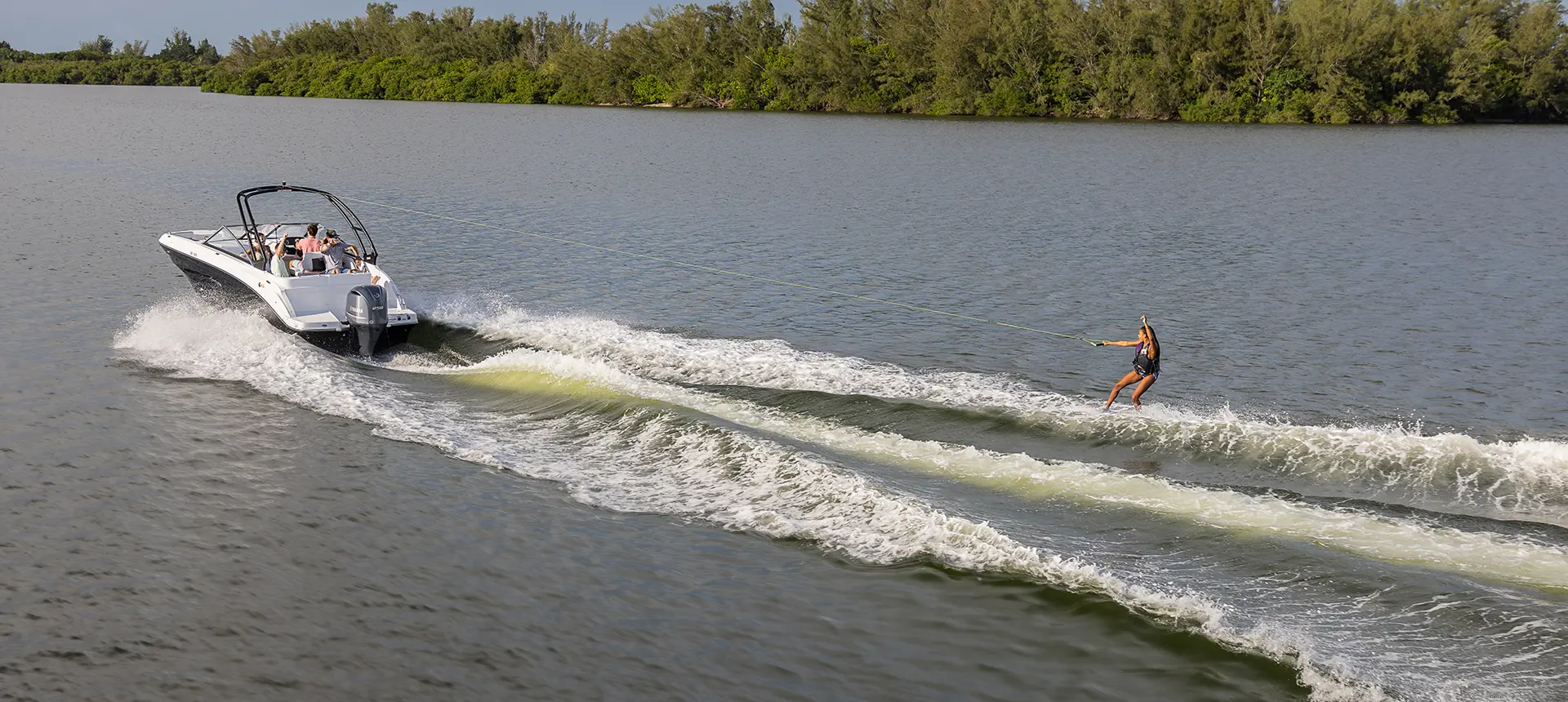 Wake boarder jumping waves behind a Hurricane sport boat.