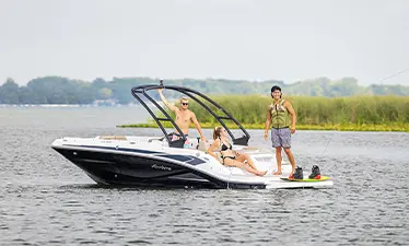 Wakeboarder throwing out tow rope behind a Hurricane sport boat.