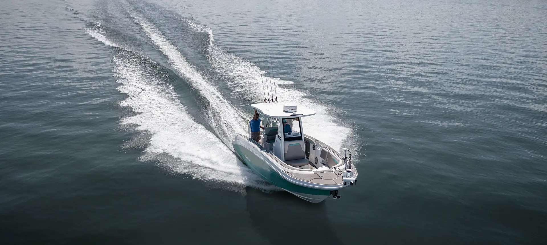 2 people cruising the ocean a Hurricane Center Console fishing deck boat.