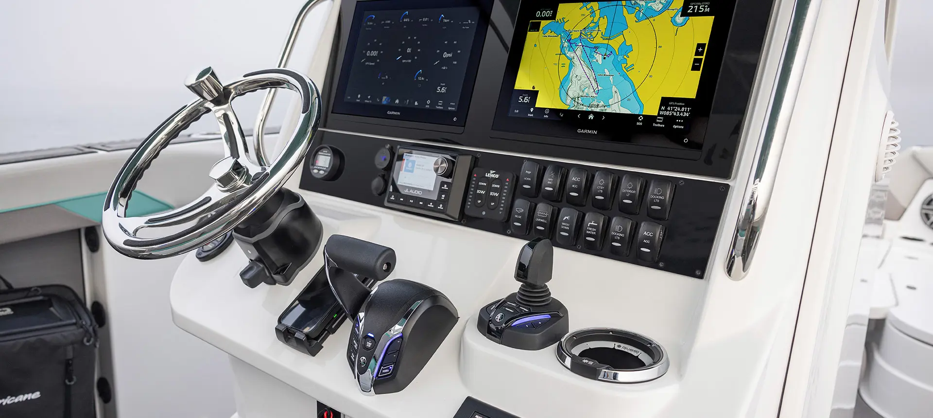 Close up of the steering wheel, gauges, knobs and displays on the helm of a Hurricane Center Console fishing deck boat.