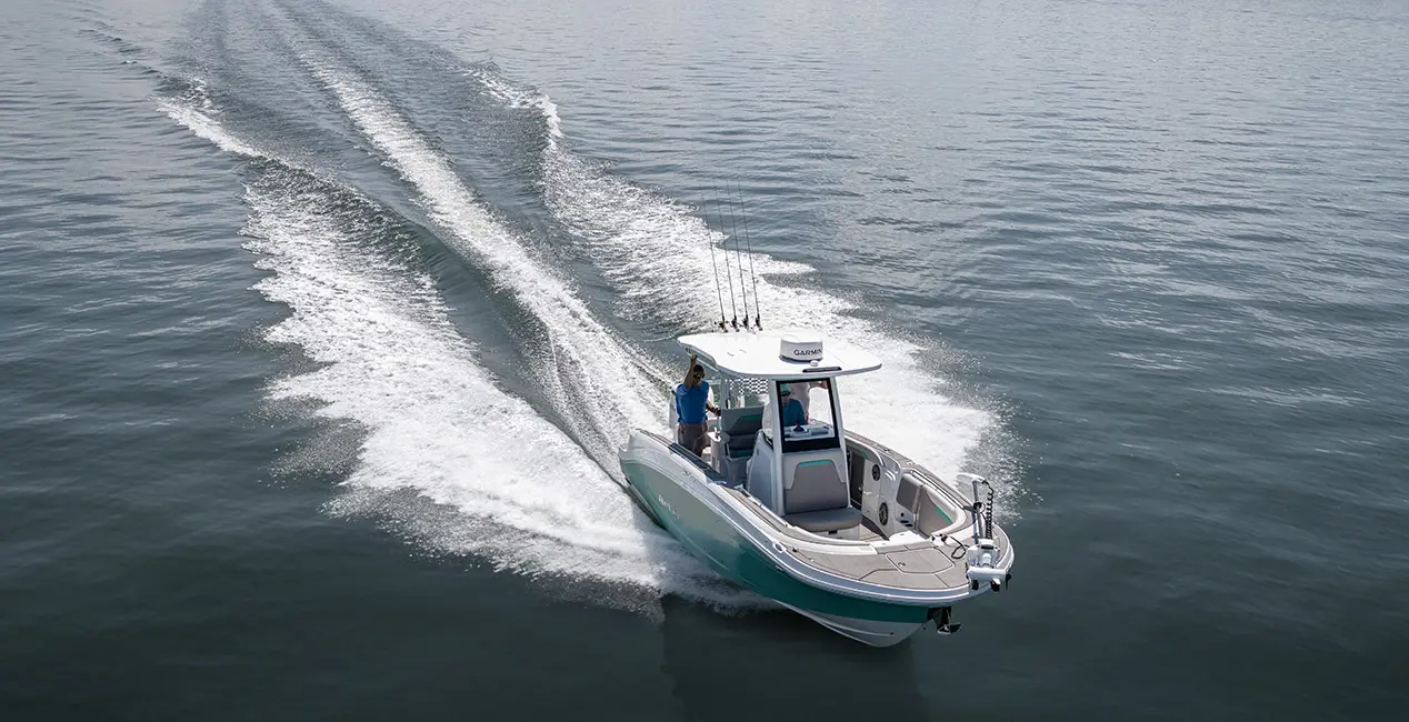 2 people cruising the ocean a Hurricane Center Console fishing deck boat.