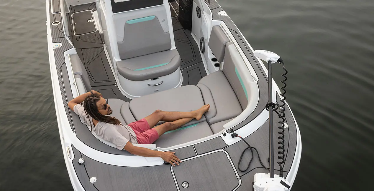 Aerial view of a man relaxing on the bow seating of a Hurricane Center Console fishing deck boat.