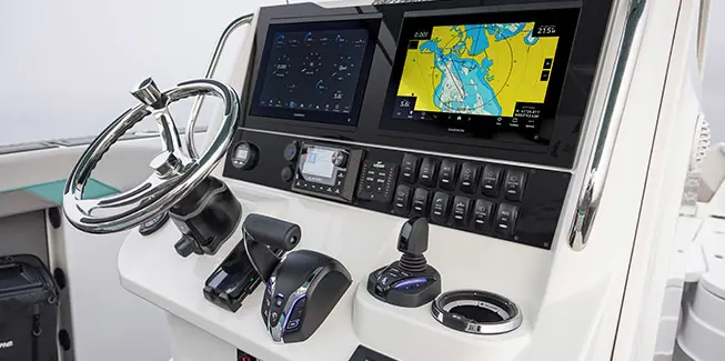 Close up of the steering wheel, gauges, knobs and displays on the helm of a Hurricane Center Console fishing deck boat.