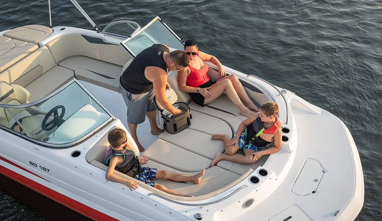 A family relaxing on the bow seating of a Hurricane 187 IO deck boat.