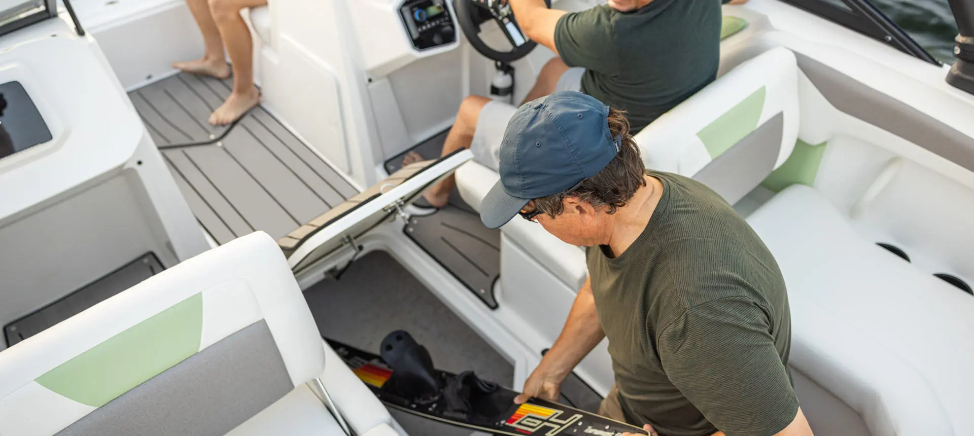 Passenger removing skis from storage compartment on a Hurricane Sundeck 2050 OB.