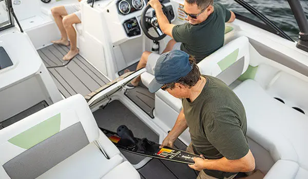 Passenger removing skis from storage compartment on a Hurricane Sundeck 2050 OB.