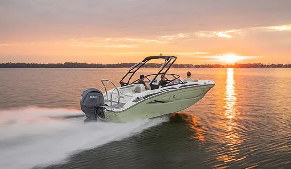 Rear-view of Hurricane Sundeck 2050 OB cruising on lake during sunset.