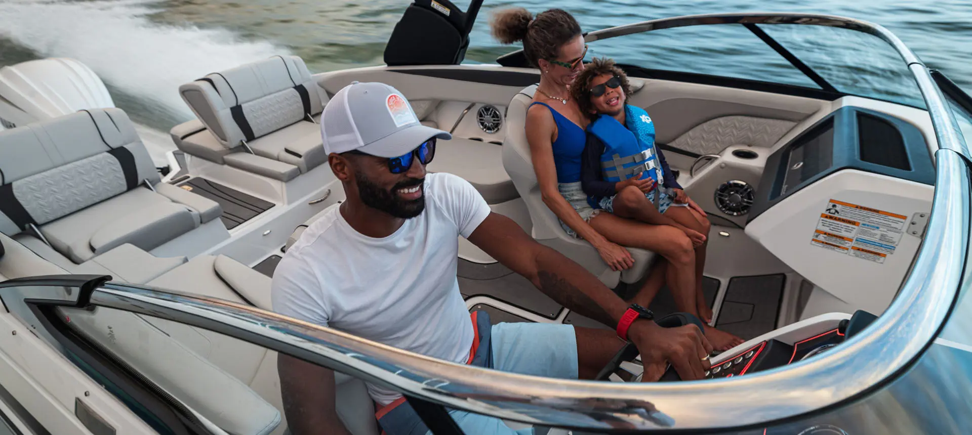 Smiling family speeds across ocean on a Hurricane Sundeck 2600 OB deck boat.