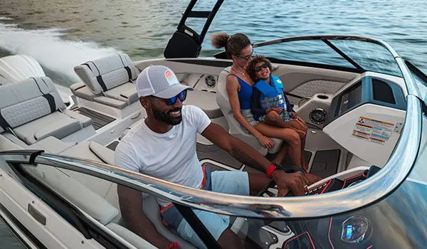 Smiling family speeds across ocean on a Hurricane Sundeck 2600 OB deck boat.