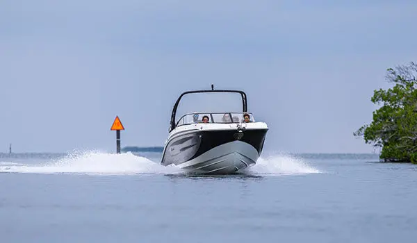 Hurricane Sundeck 2600 OB deck boat cruising on the ocean.