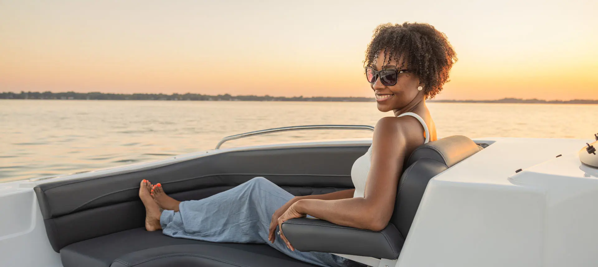 Woman lounges on front seating in a Hurricane Sundeck Sport 192 RL OB.