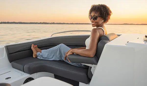 Woman lounges on front seating in a Hurricane Sundeck Sport 192 RL OB.