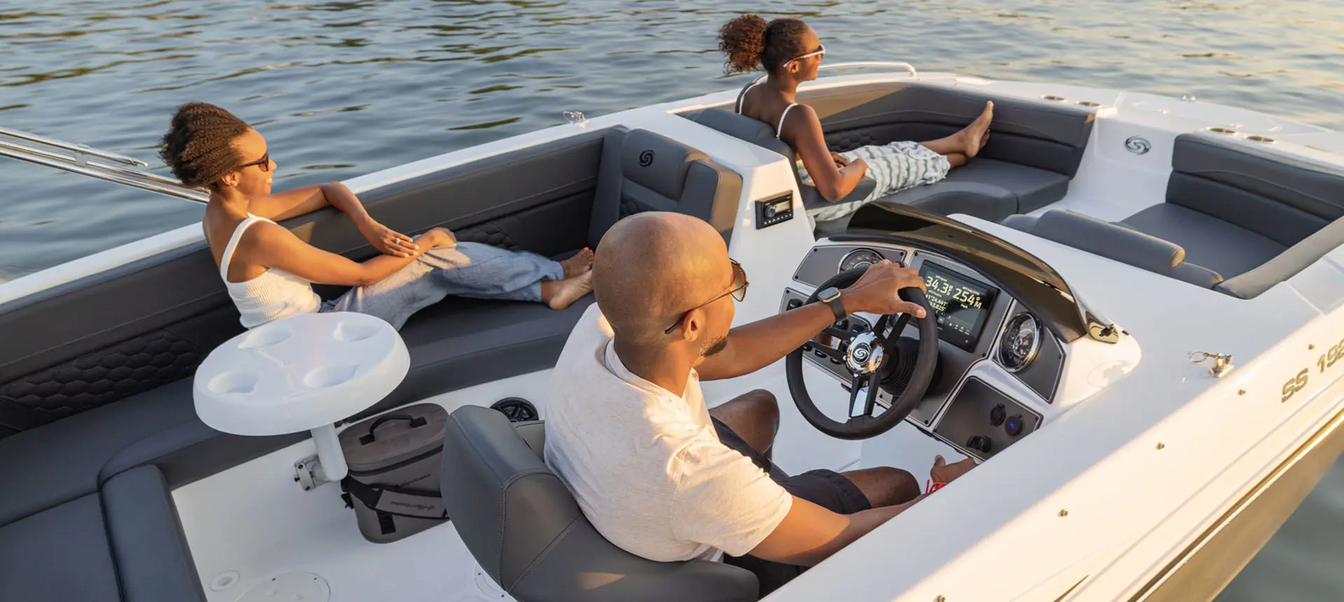 Family cruises on lake on a Hurricane Sundeck Sport 192 RL OB.