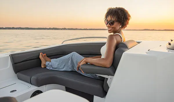 Woman lounges on front seating in a Hurricane Sundeck Sport 192 RL OB.