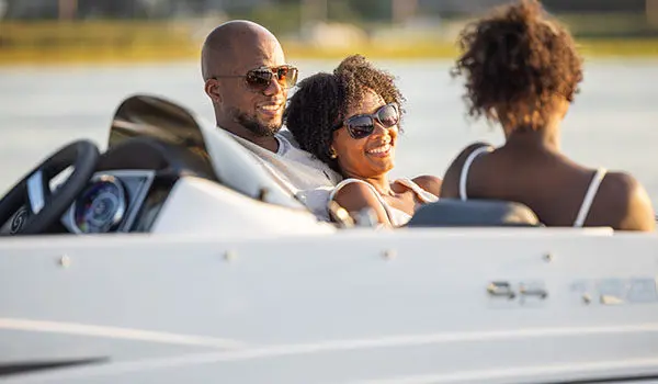 Family smiles while lounging on front seating on Hurricane Sundeck Sport 192 RL OB.