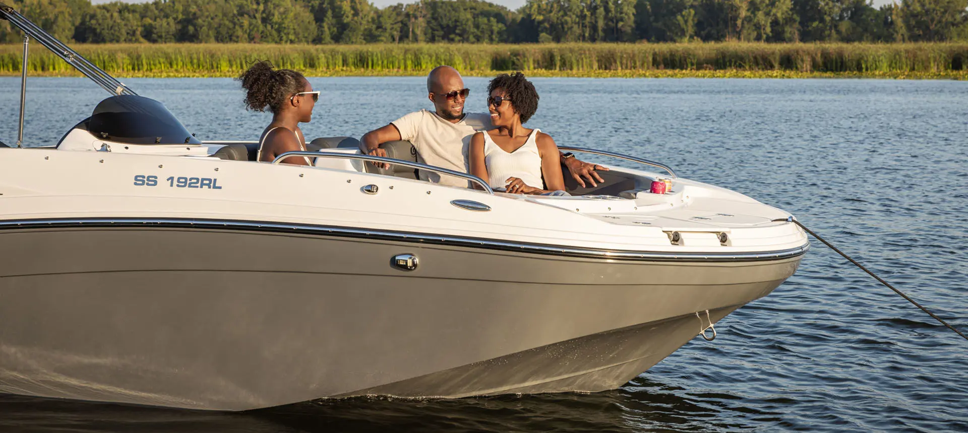 Family smiles while seated in front seating of a Hurricane Sundeck Sport 192 RL OB.