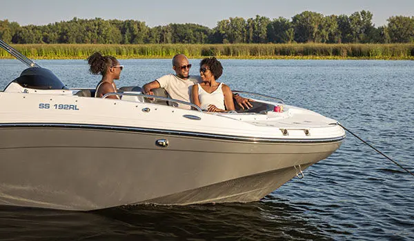 Family smiles while seated in front seating of a Hurricane Sundeck Sport 192 RL OB.