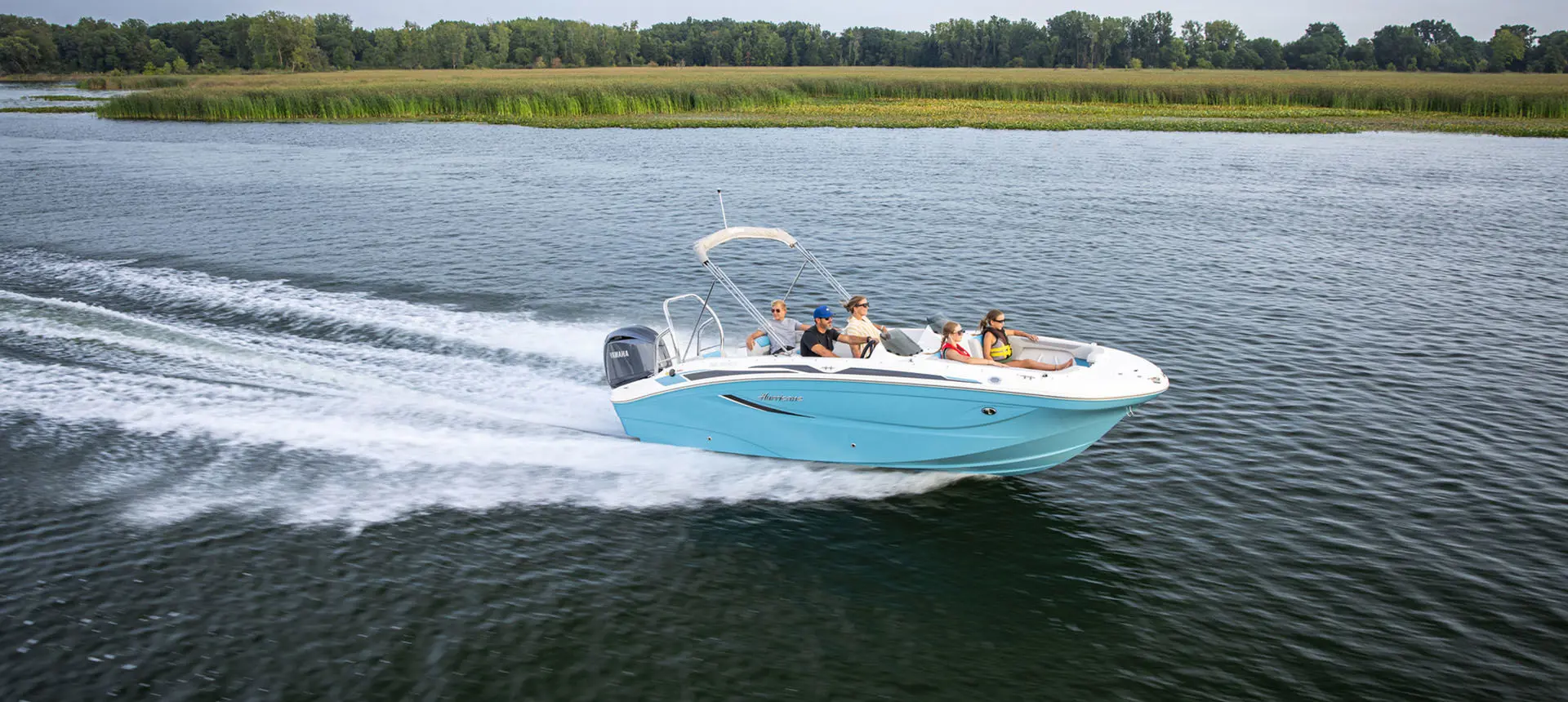 Family speeds across lake on a Hurricane Sundeck Sport 2050 OB.