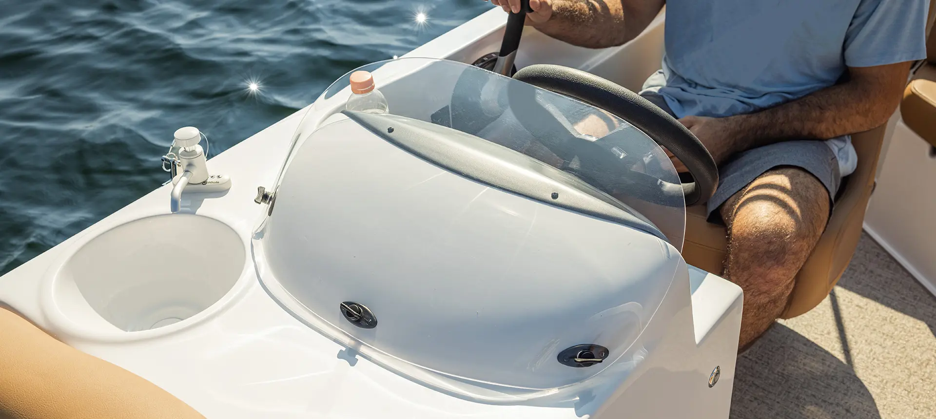 Closeup of the windshield on the captain's helm of a Hurricane SunDeck Sport I/O deck boat.