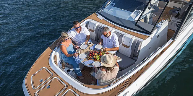 Aerial view of 4 people enjoying a mean at the bow table on a Hurricane yacht certified deck boat.