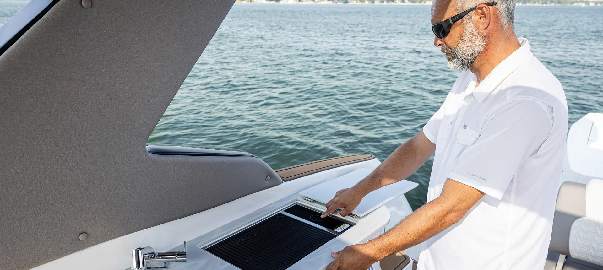 Man using the stove on a Hurricane Entertainment deck boat.