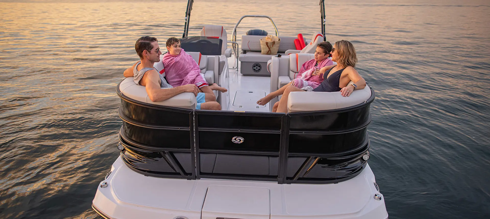 Family of 4 relaxing on the bow seating on a Hurricane Entertainment deck boat.