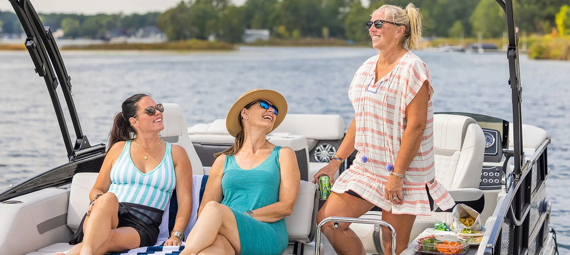 3 women smiling on a Hurricane Entertainment deck boat.