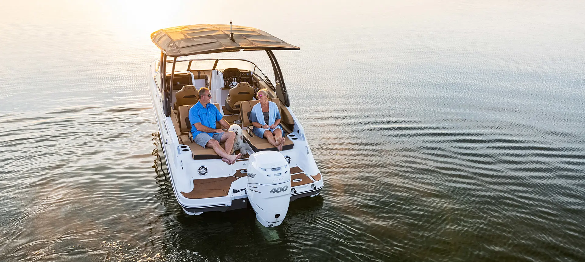 Stern focused aerial view of 2 people relaxing on a Hurricane Entertainment deck boat.