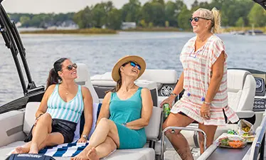 3 women smiling on a Hurricane Entertainment deck boat.