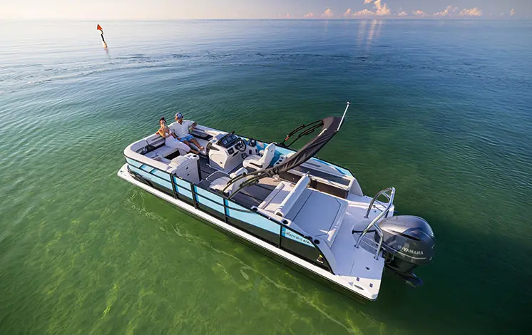 Aerial view of 2 people relaxing on the bow of a Hurricane Entertainment deck boat.