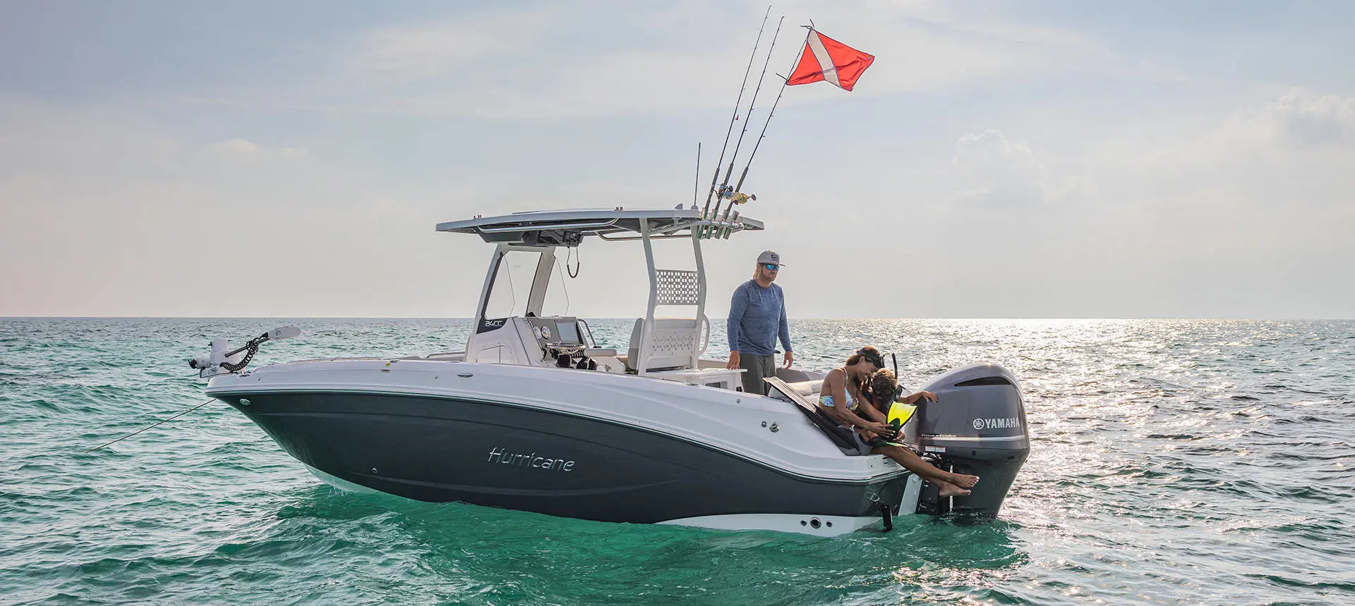 2 people preparing to snorkel off the stern of a Hurricane Center Console deck boat.