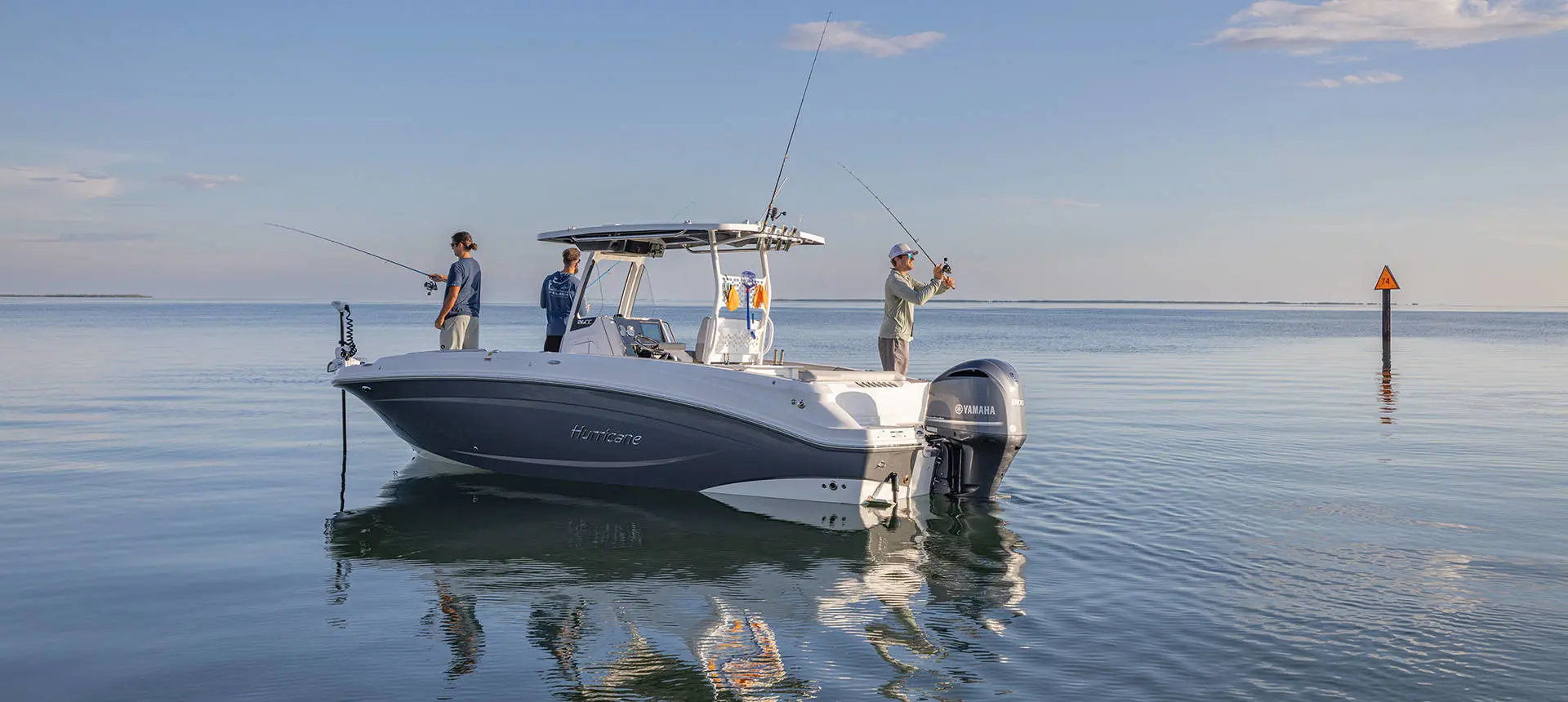 3 men fishing on a parked Hurricane Center Console deck boat.