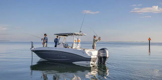 3 men fishing on a parked Hurricane Center Console deck boat.
