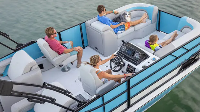 4 people relaxing while cruising the lake on their Hurricane FunDeck deck boat.