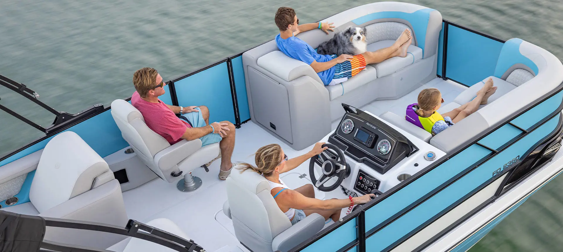 4 people relaxing while cruising the lake on their Hurricane FunDeck deck boat.