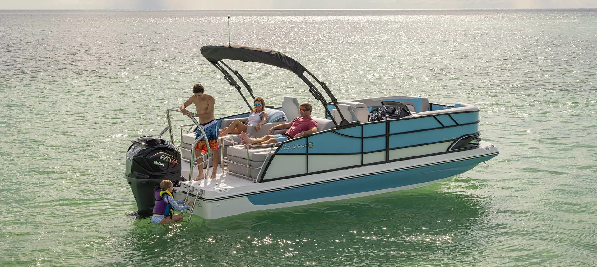 A girl climbing the stern ladder onto a Hurricane FunDeck deck boat while her family watches.