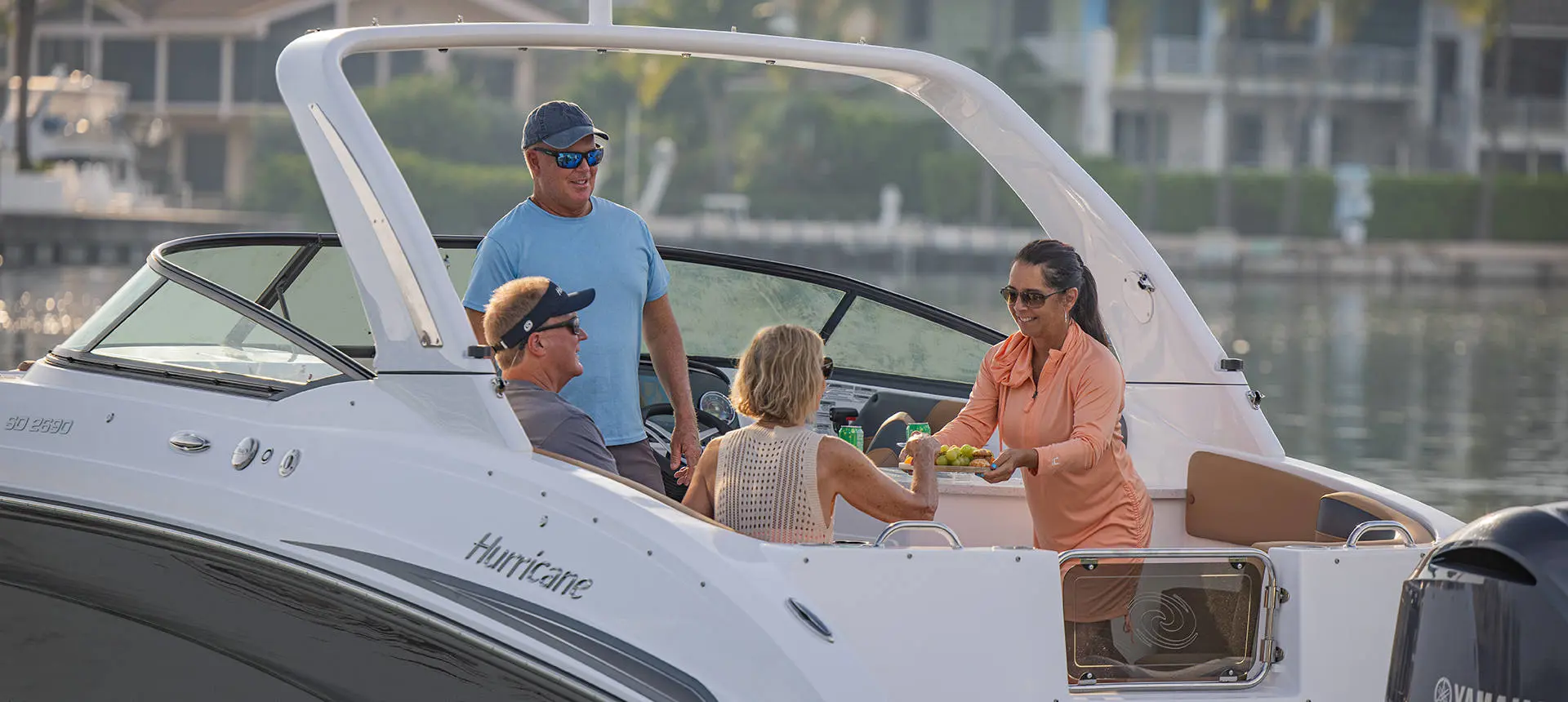 4 people enjoying a snack on a Hurricane SunDeck OB deck boat.