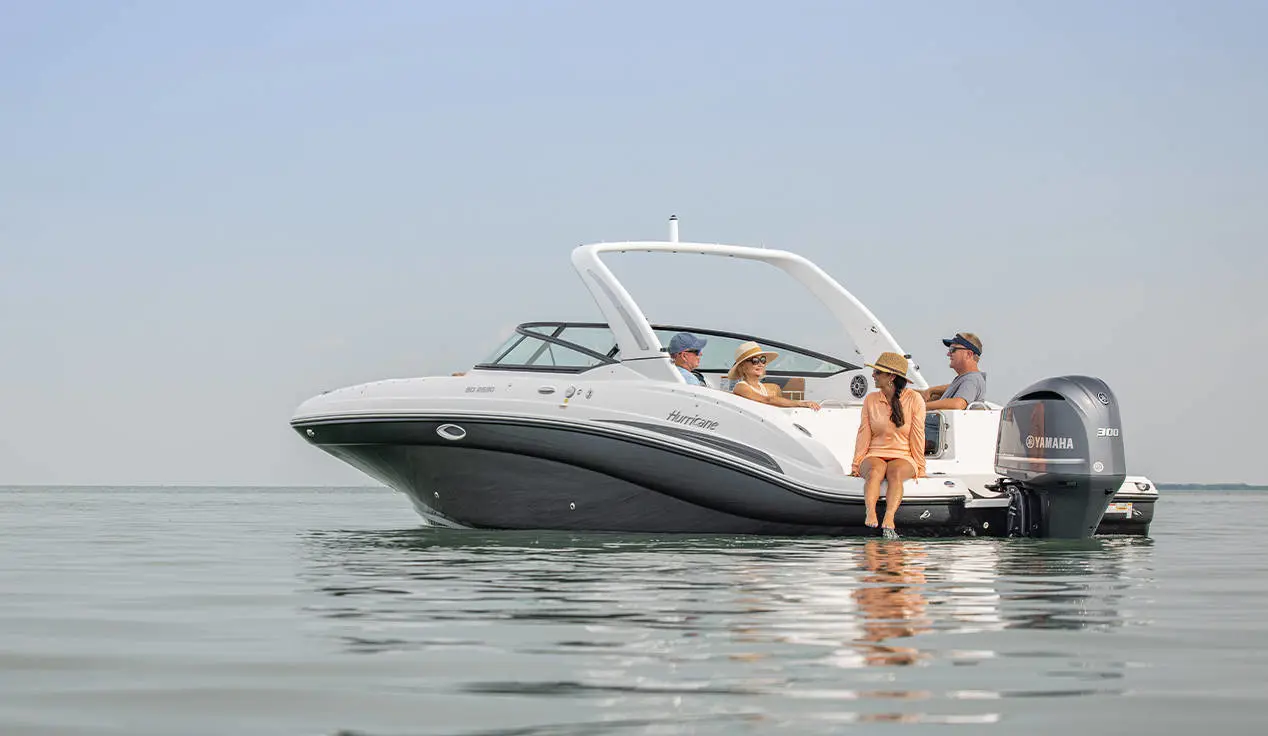 4 people relaxing on a Hurricane SunDeck OB deck boat while floating the lake.
