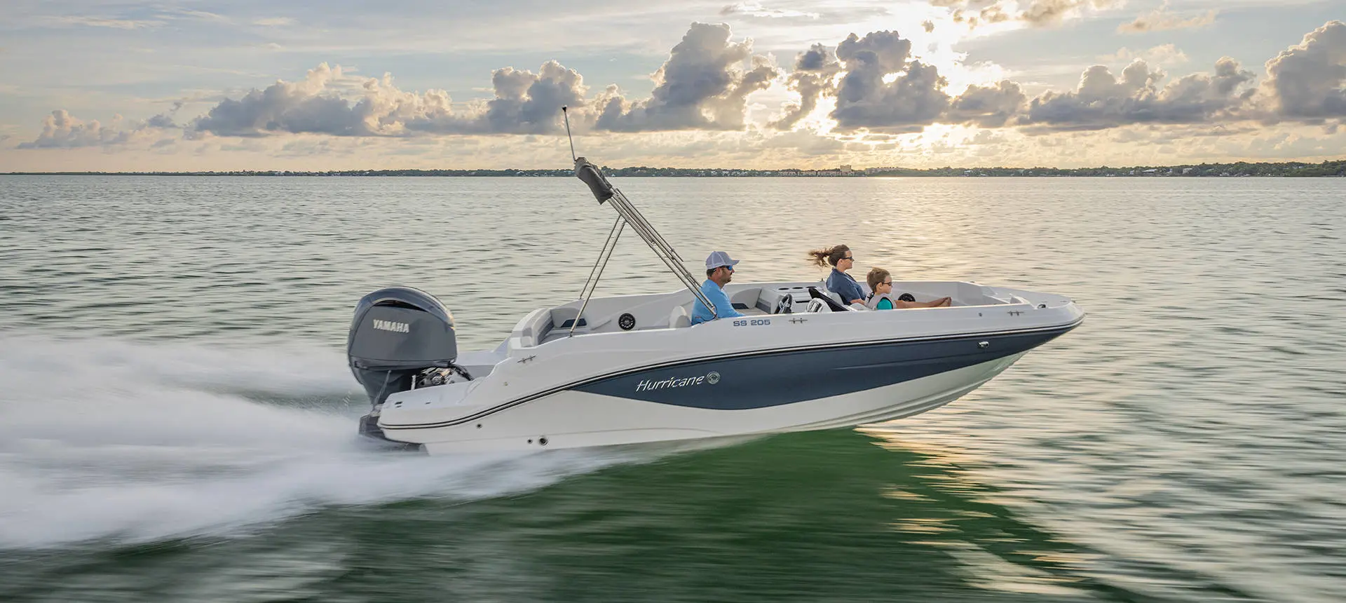 A family cruising the ocean on their Hurricane SunDeck Sport 205 OB deck boat.