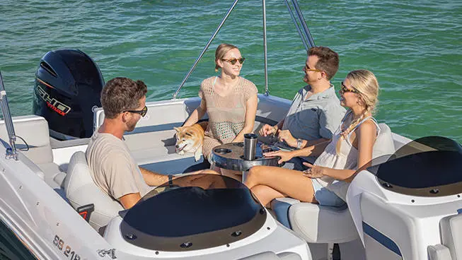 4 people relaxing on the bow seating of a Hurricane SunDeck Sport 218 OB deck boat