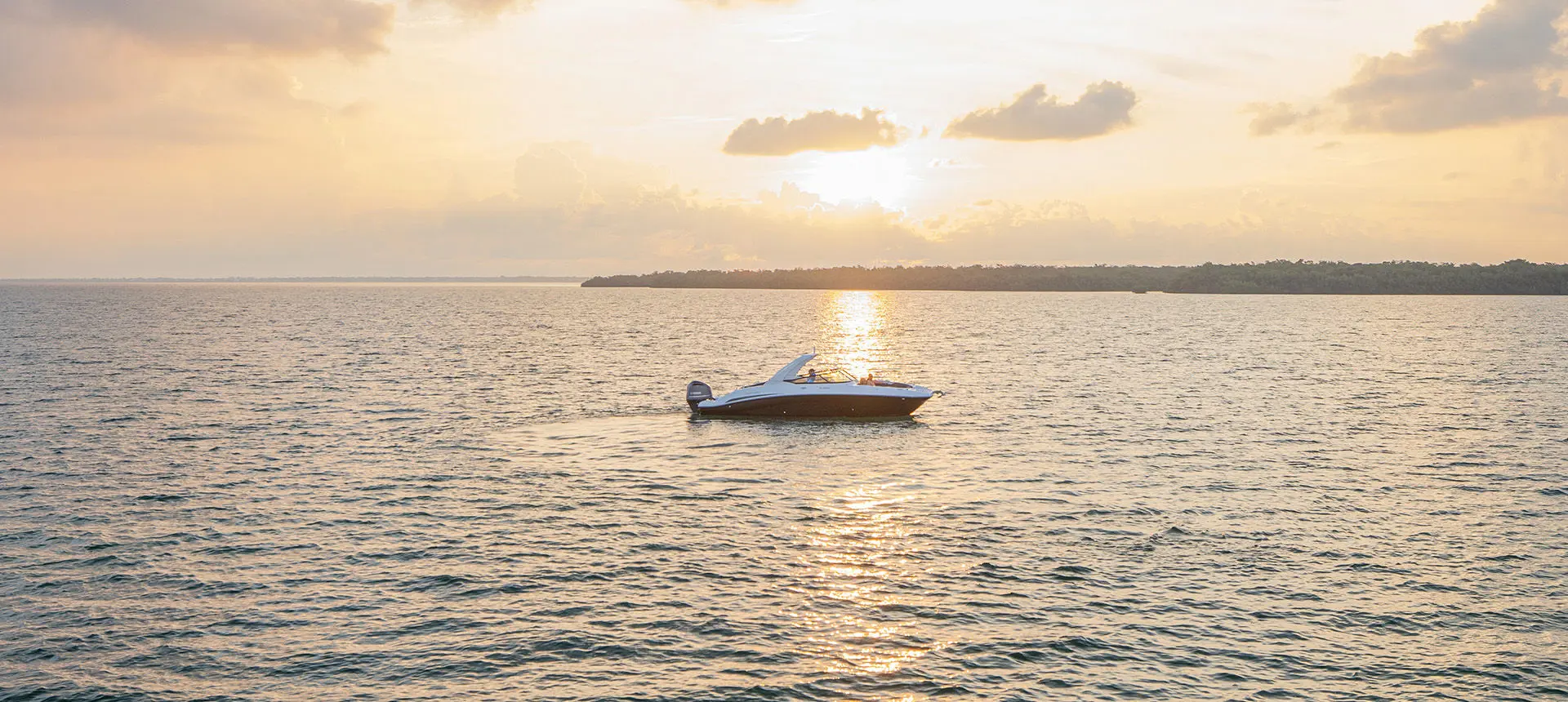 A Hurricane Yacht Certified boat floating on the ocean at sunset.